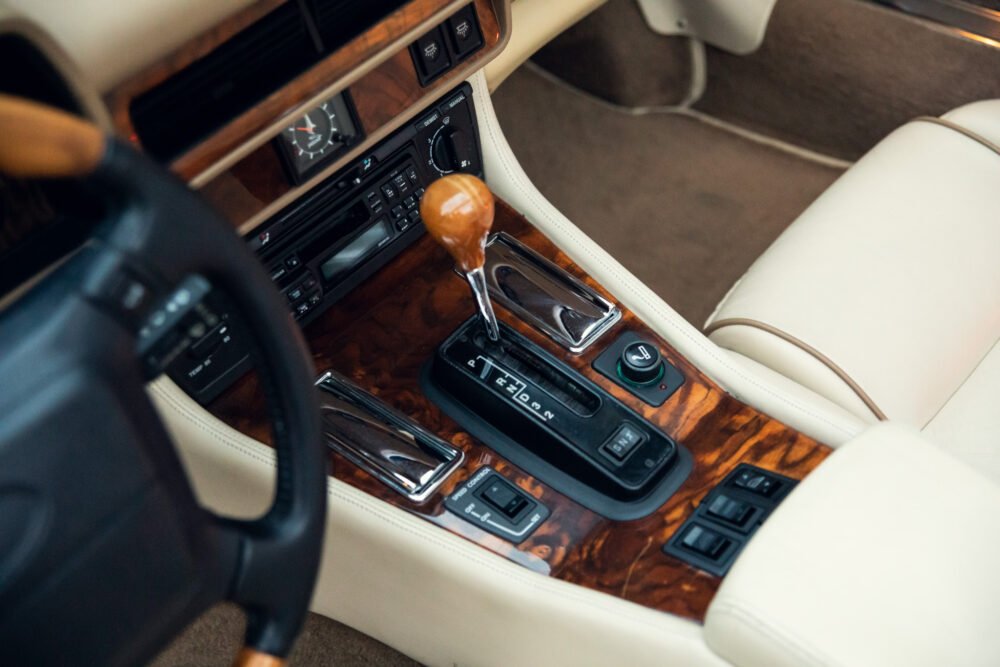 Vintage car interior with wooden accents and gear shift.