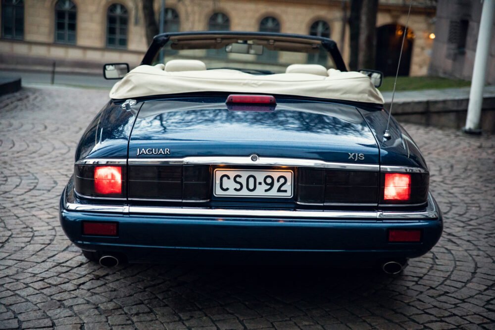 Vintage Jaguar XJS convertible, rear view, on cobblestone.