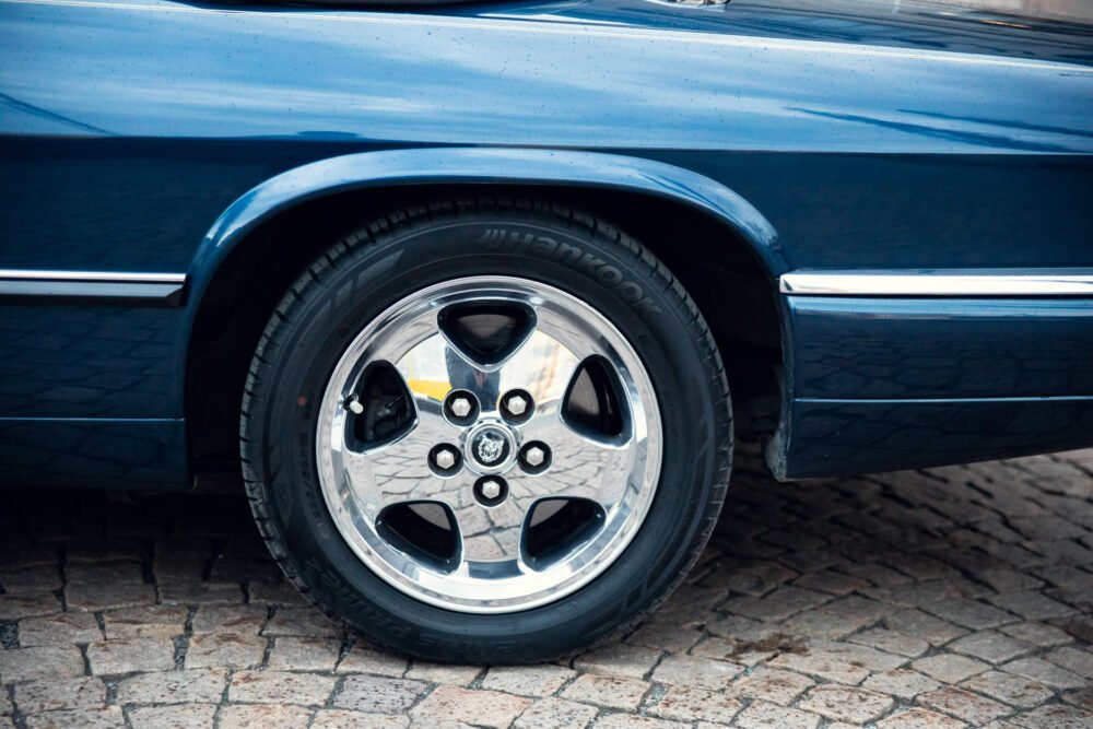 Close-up of blue car's shiny chrome wheel.