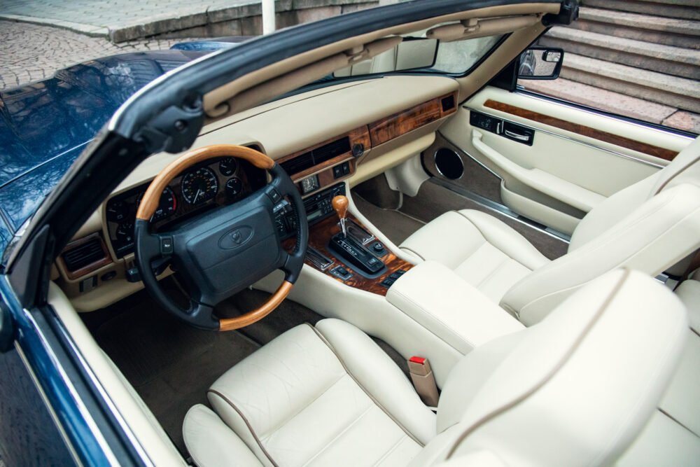 Luxurious car interior with wood detailing and leather seats.