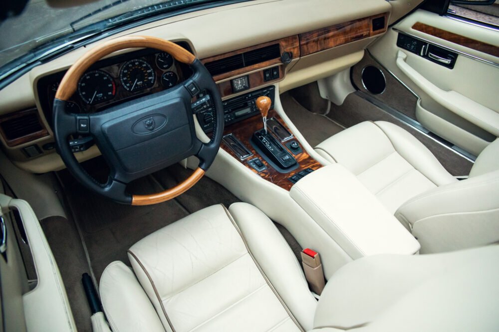 Luxury car interior with leather seats and wooden dashboard.