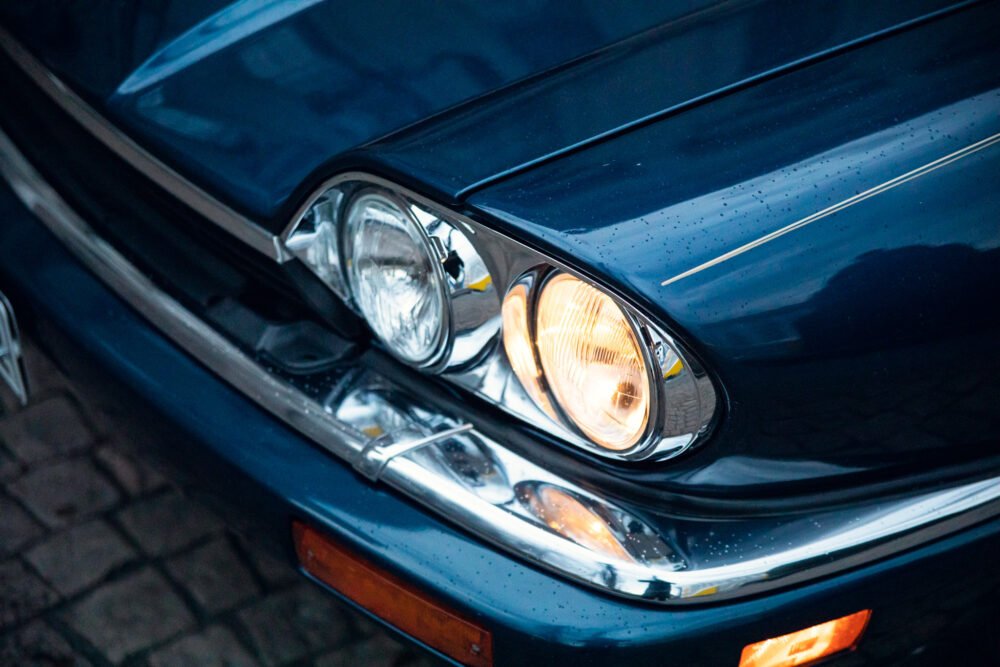 Close-up of blue car's headlights and grille.