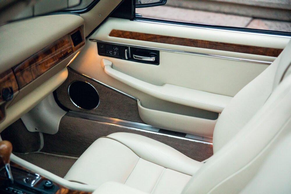 Luxurious car interior with leather seats and wood trim.