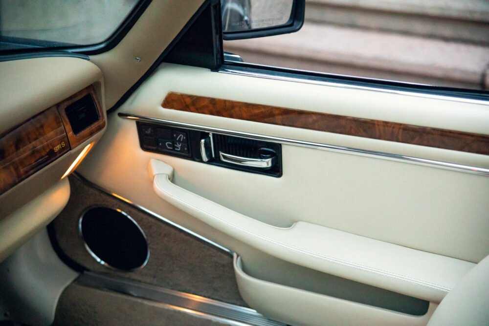 Luxurious car interior with wood trim and white leather.