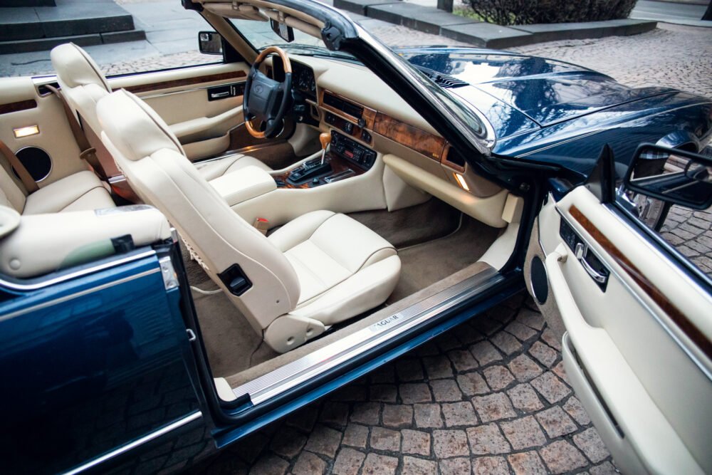 Luxury car interior with open door and elegant design.