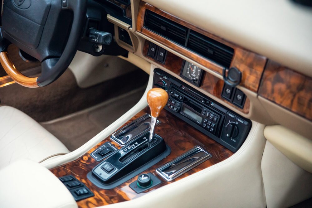 Luxury car interior with wooden accents and leather seats.