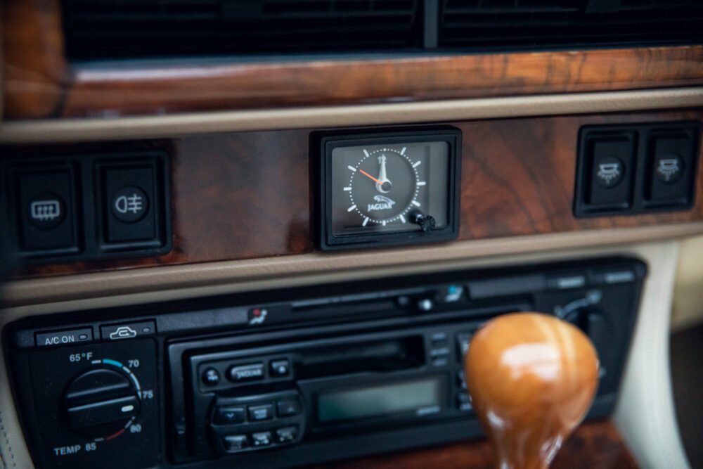 Jaguar car dashboard with clock and controls.