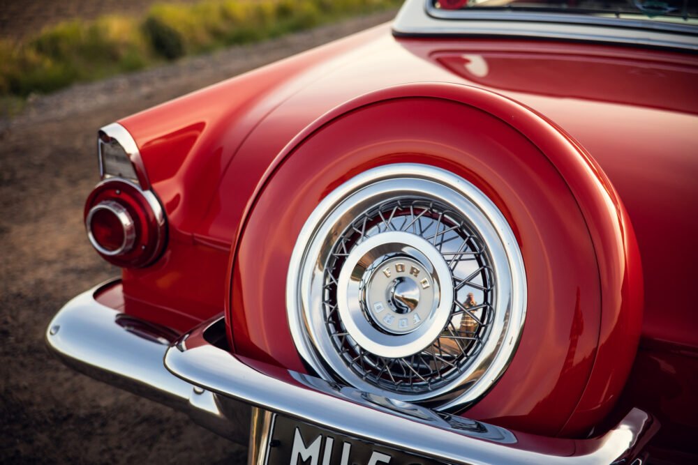 Classic red car with chrome spare tire detail.