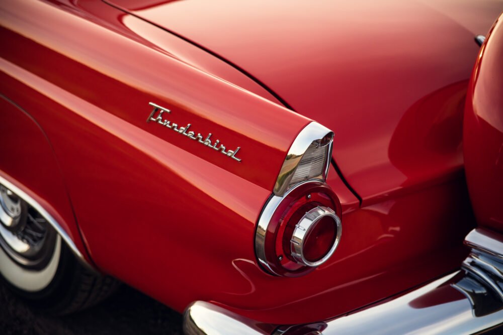Close-up of red Thunderbird car's tail fin and logo.