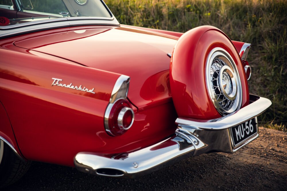 Vintage red Thunderbird car with spare tire detail.