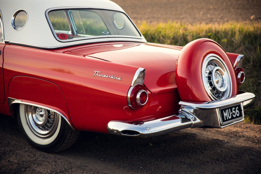 Vintage red Thunderbird car, spare tire detail.