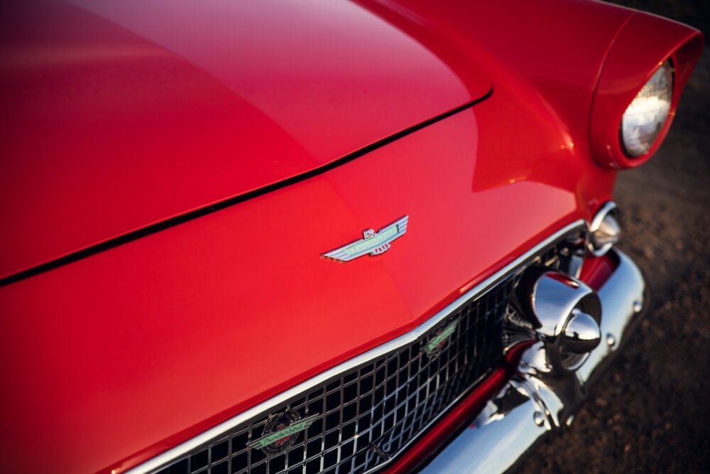 Red vintage Thunderbird hood and emblem detail.