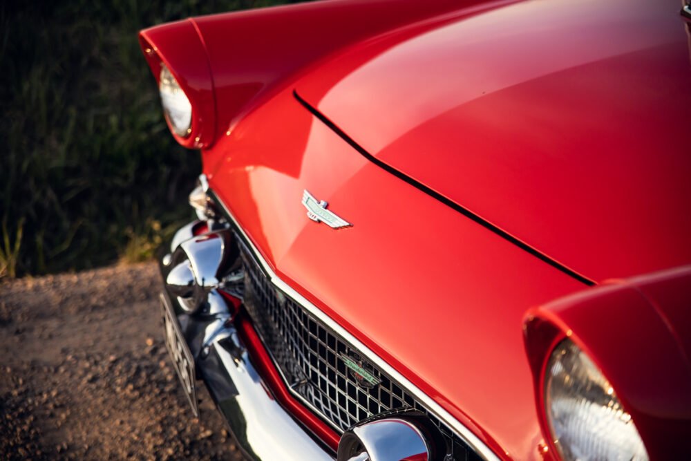 Red vintage car front detail, sleek design.
