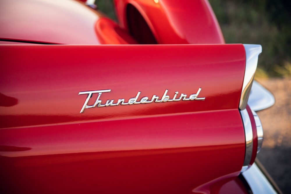 Close-up of red Thunderbird car emblem.