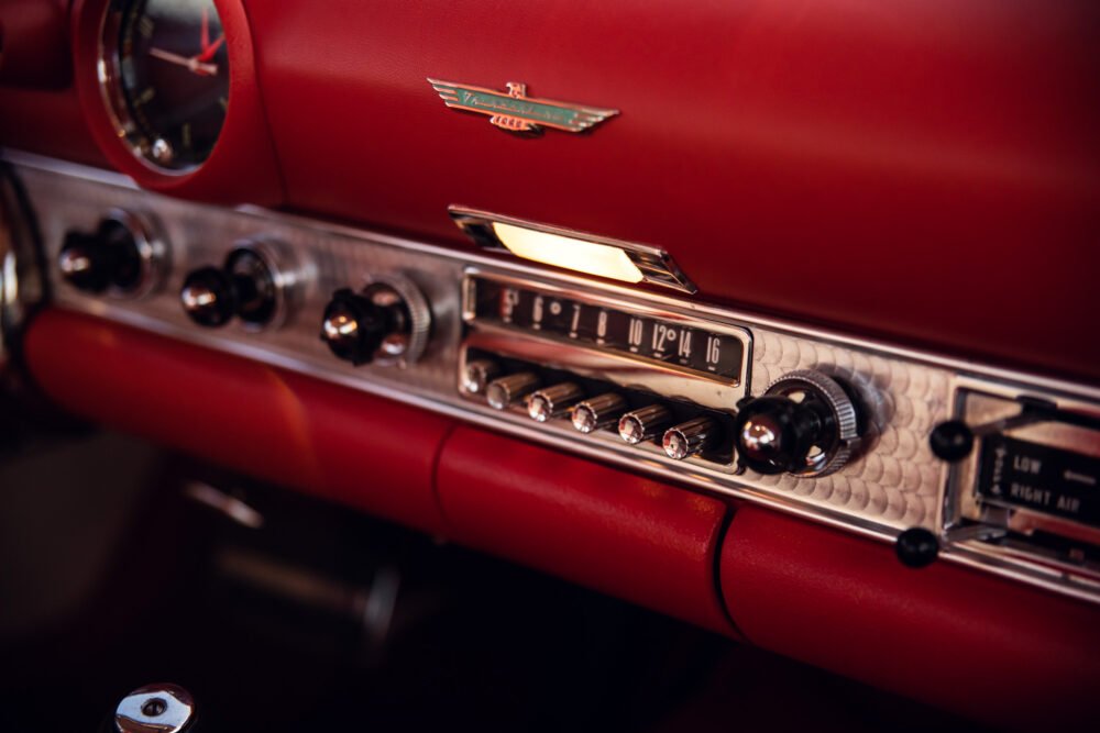 Vintage car dashboard with red interior and chrome details.