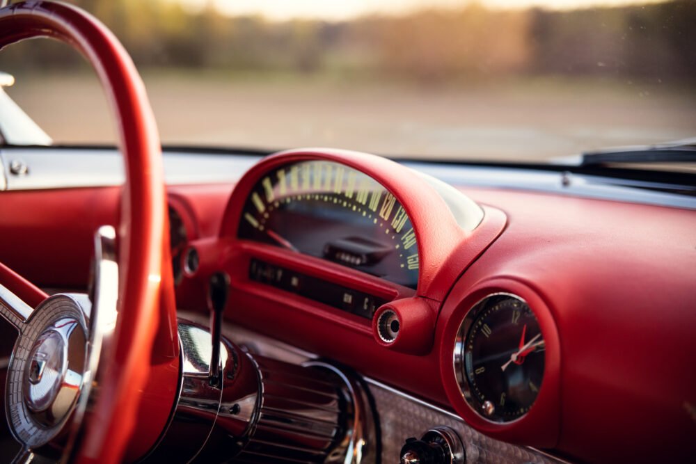 Vintage red car dashboard in sunlight.