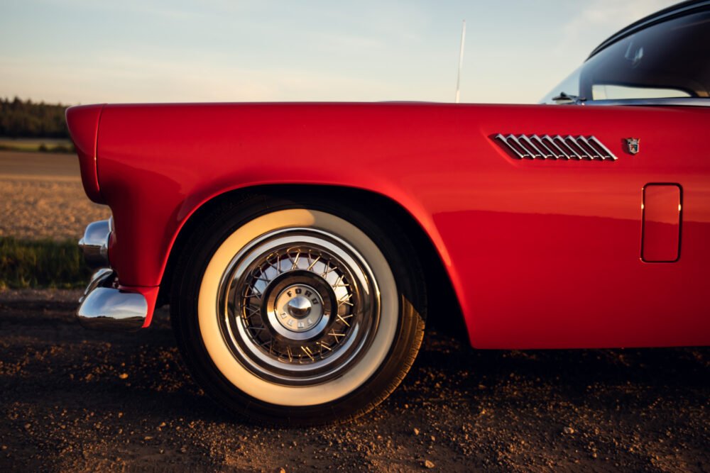 Red vintage car's side view at sunset.