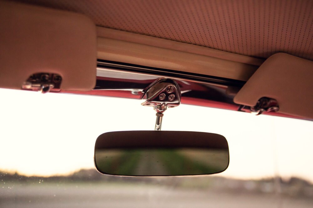 Vintage car interior with rearview mirror.