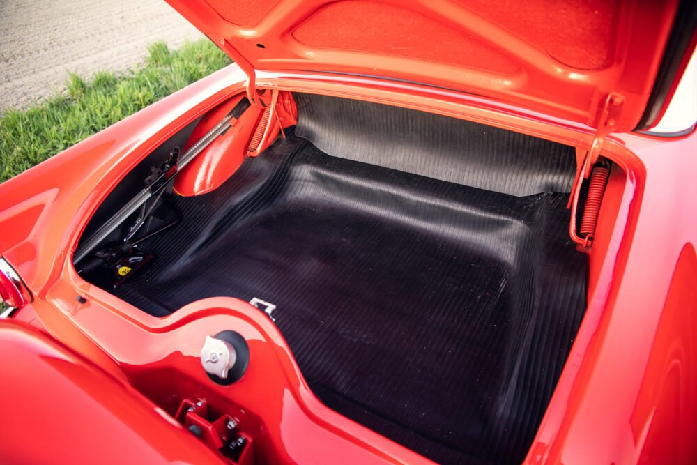 Red sports car's open trunk showing detailed interior.