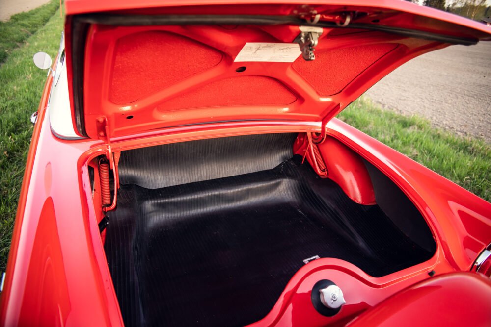 Red vintage car trunk open, detailed view.