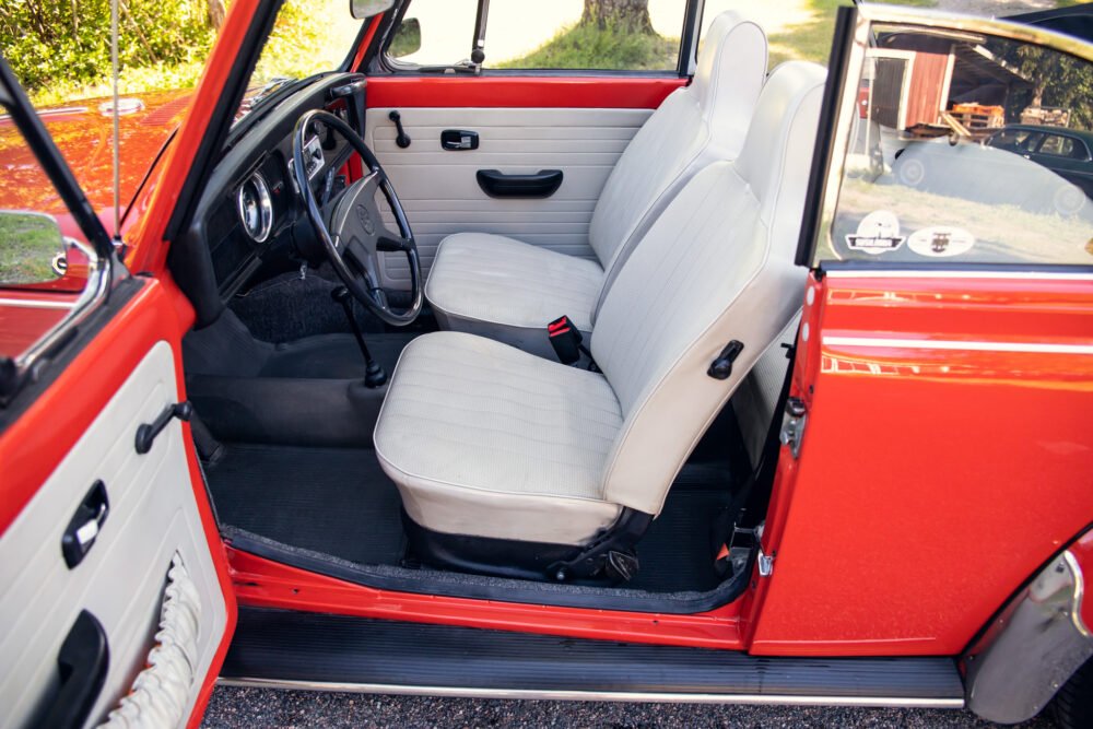 Vintage red car interior, open door view.