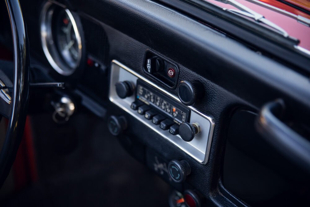 Vintage car dashboard with radio and controls.