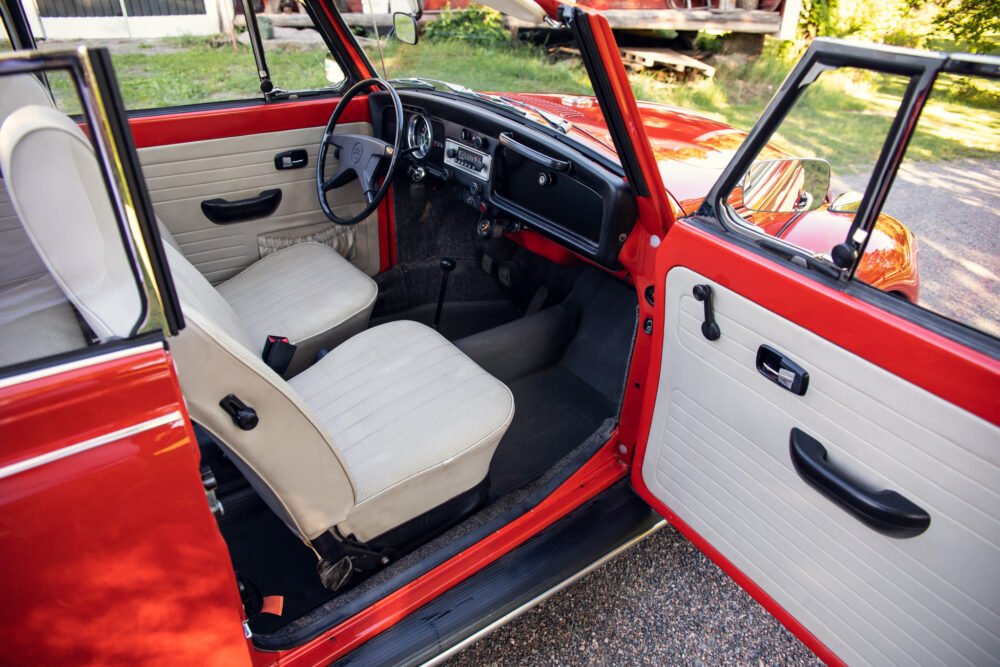 Red vintage car interior with open doors.