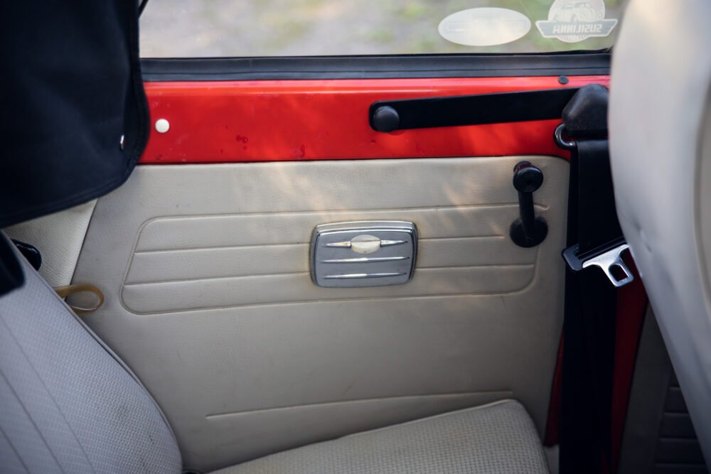 Vintage car interior with door handle and window lever.