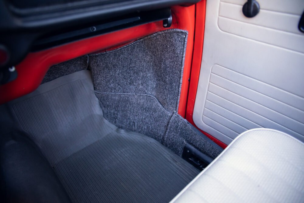 Classic car interior with red and gray upholstery.