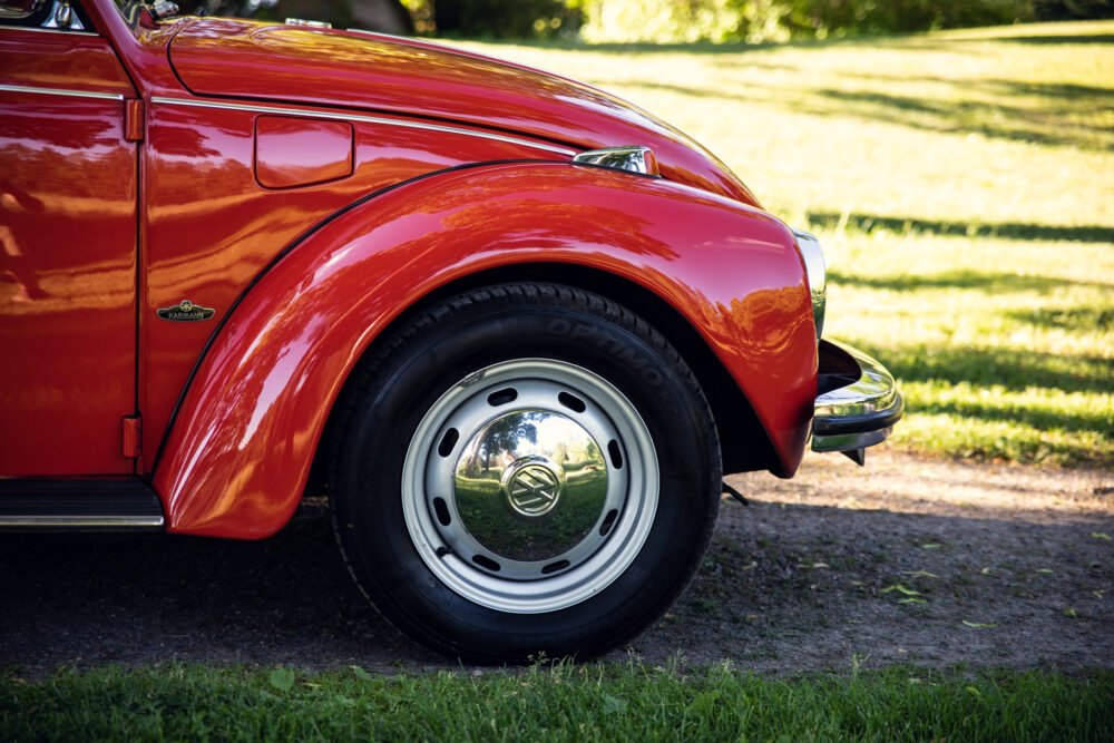 Close-up of red vintage Volkswagen Beetle wheel.