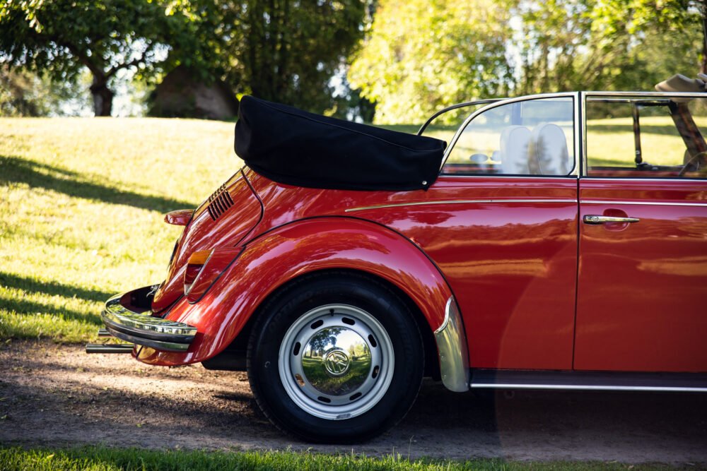 Red vintage convertible Volkswagen Beetle parked outdoors.
