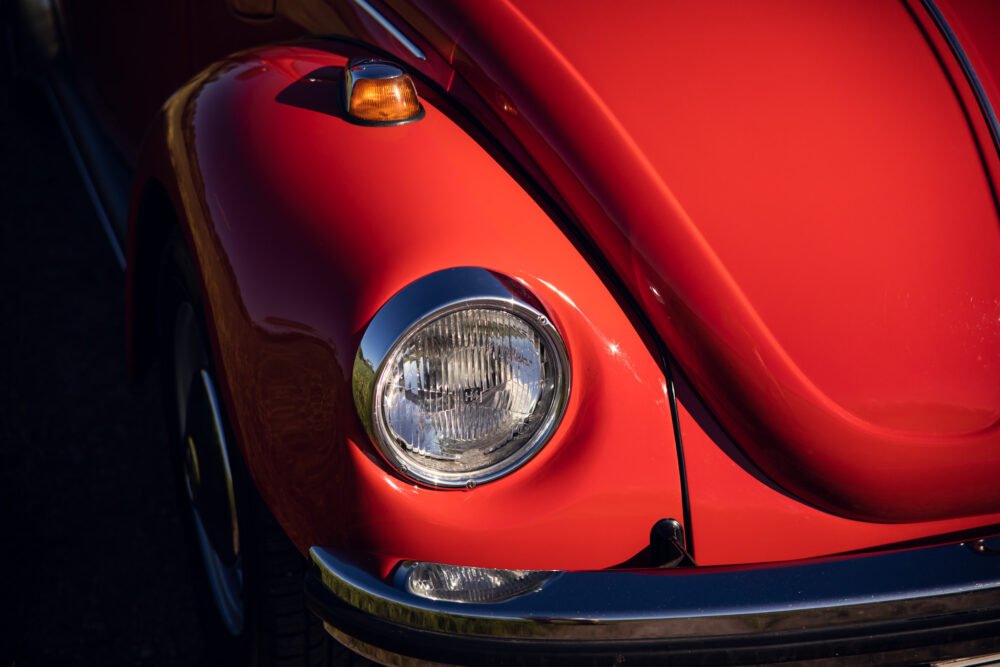 Close-up of red vintage car front with headlights.