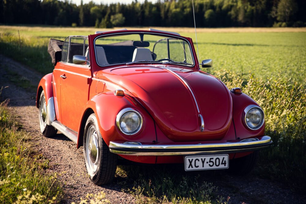 Red vintage convertible Beetle on a rural road