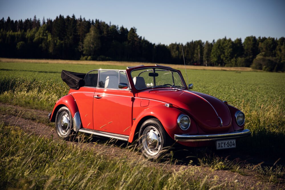 Red vintage convertible Beetle in countryside.