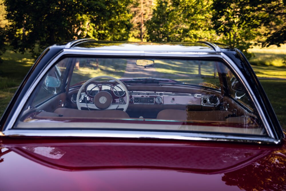 Classic car dashboard viewed through windshield.