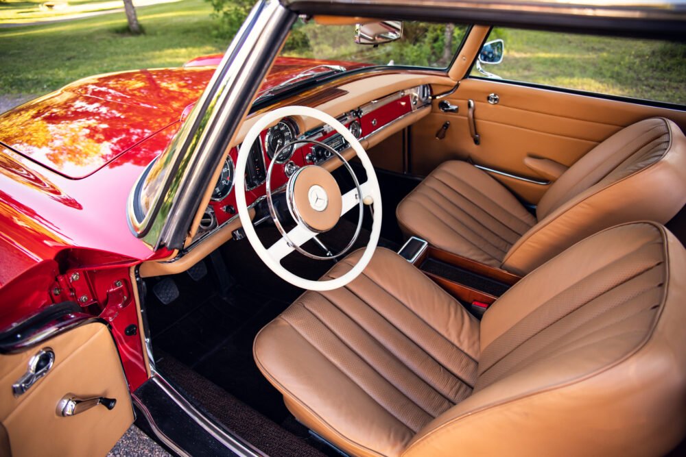 Vintage red car interior with tan leather seats.