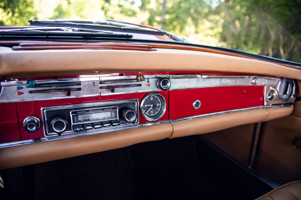 Vintage car dashboard with radio and clock.