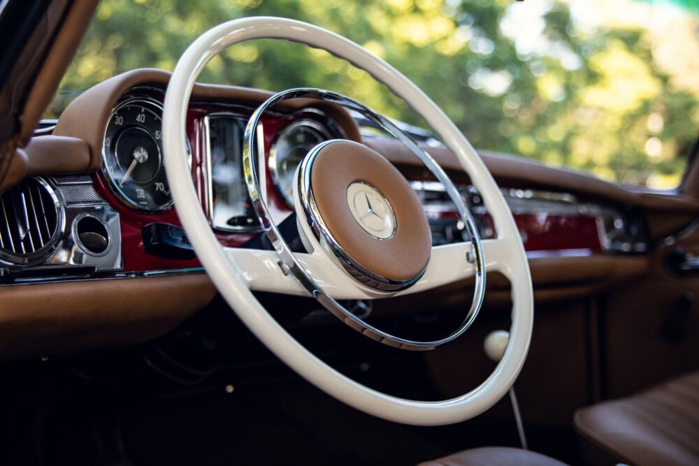 Vintage Mercedes-Benz car interior, steering wheel and dashboard.