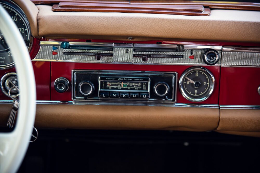 Vintage car dashboard with classic stereo and clock.