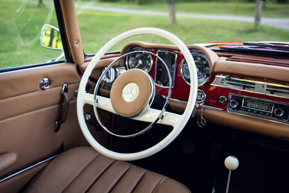 Vintage Mercedes interior with classic steering wheel.