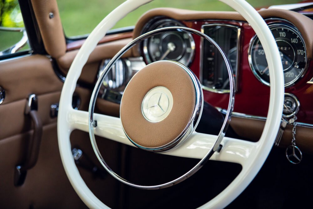 Vintage Mercedes dashboard and steering wheel close-up.