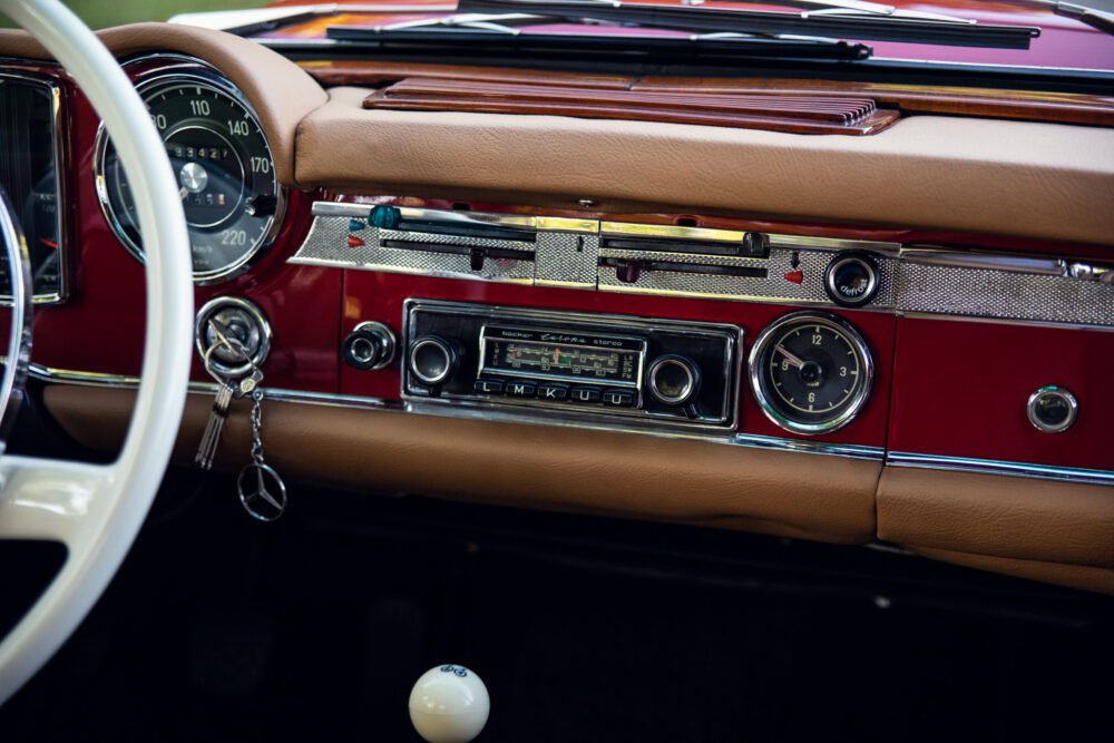 Vintage car interior with classic dashboard and steering wheel.