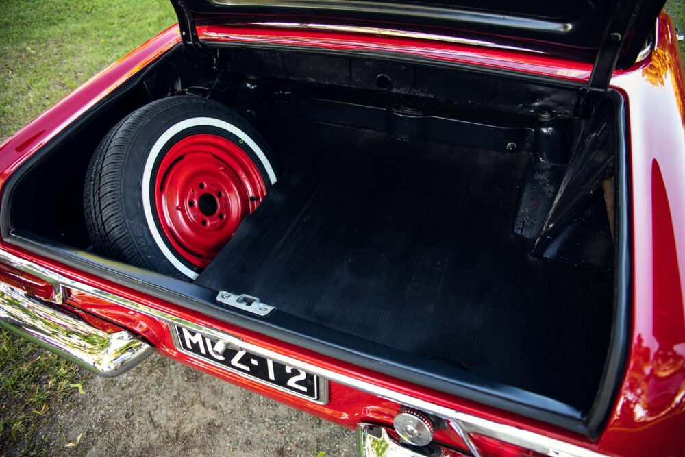 Vintage red car trunk with spare tire.