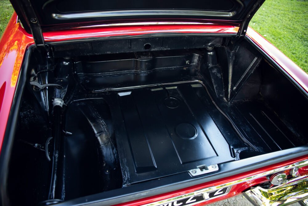 Red car's open trunk showing empty interior.