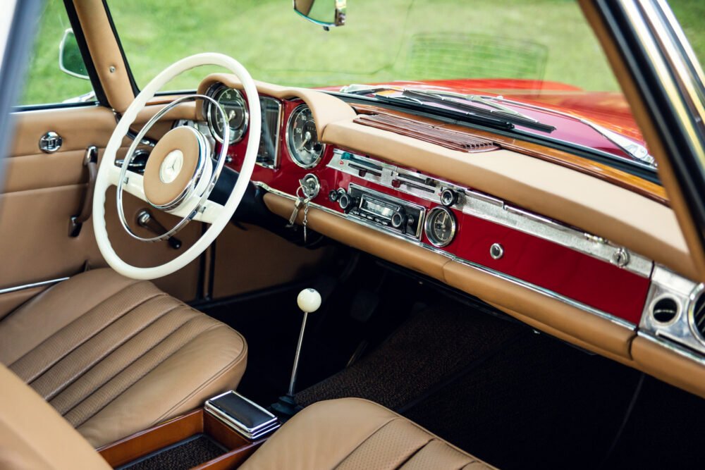 Vintage car interior with elegant dashboard and steering wheel.