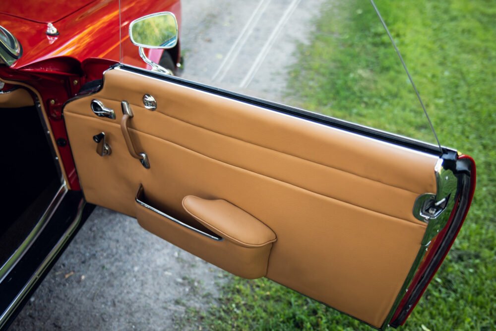 Vintage car door with tan leather interior.