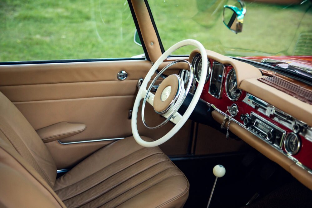 Vintage car interior with cream steering wheel.