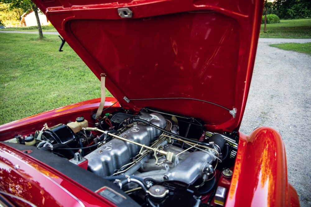 Red vintage car engine compartment open.
