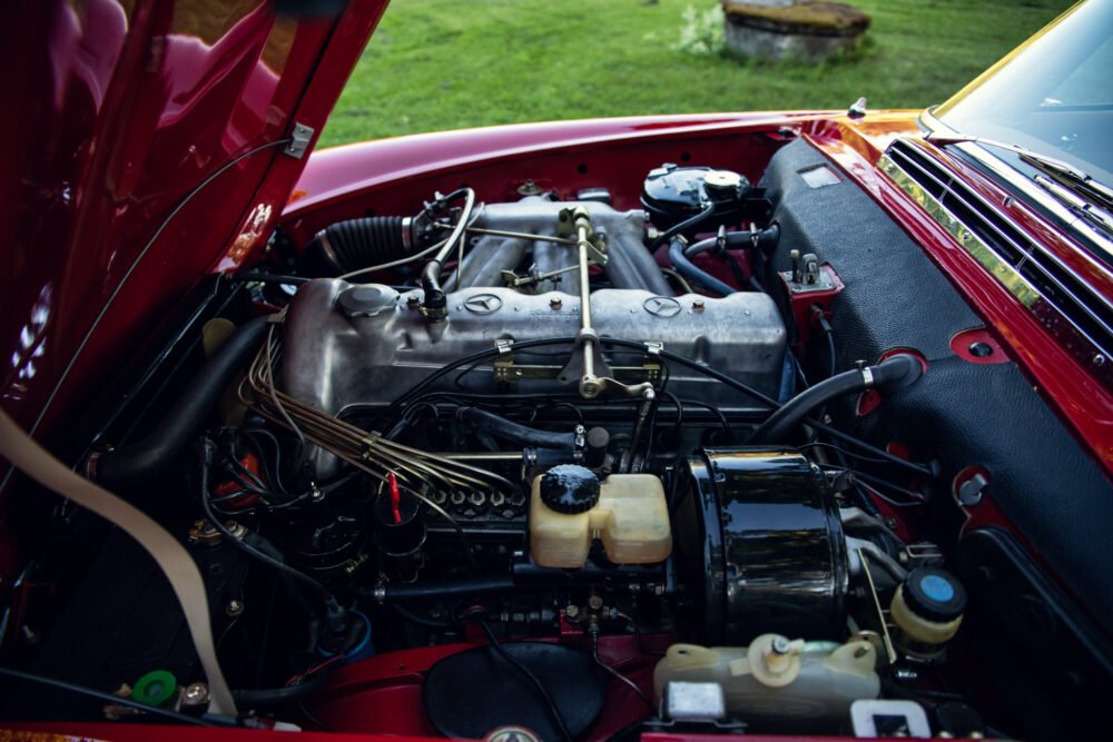 Classic car engine bay, hood open, detailed view.