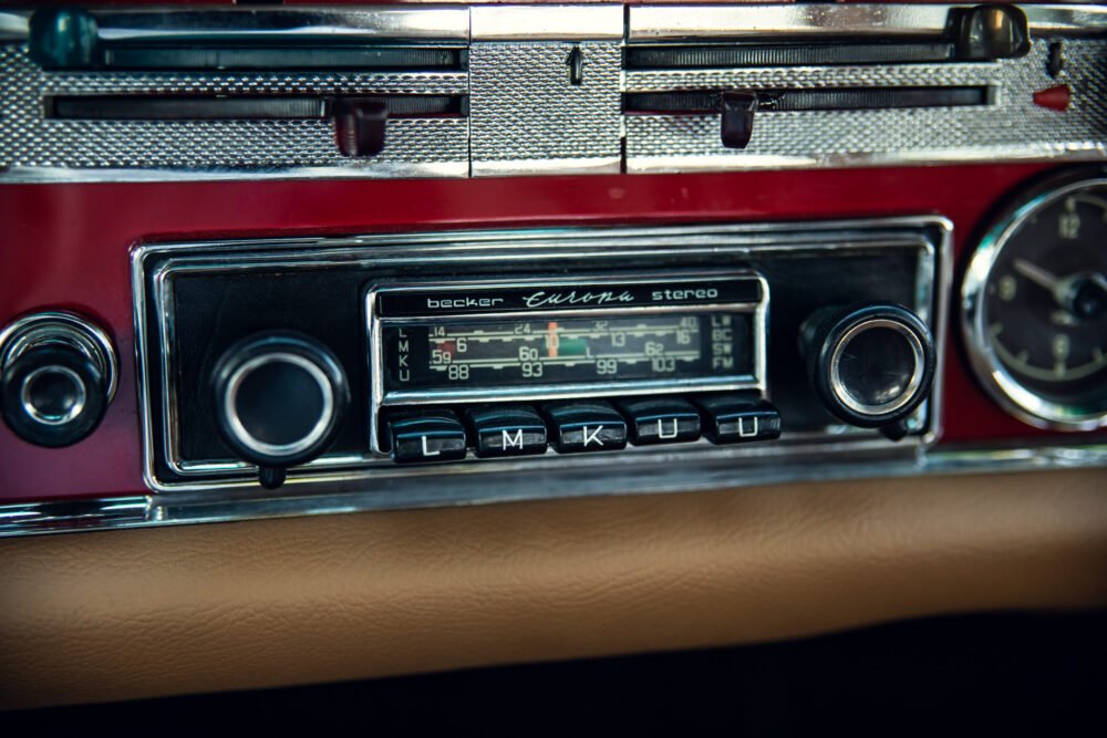 Vintage Becker Europa car stereo in red dashboard.